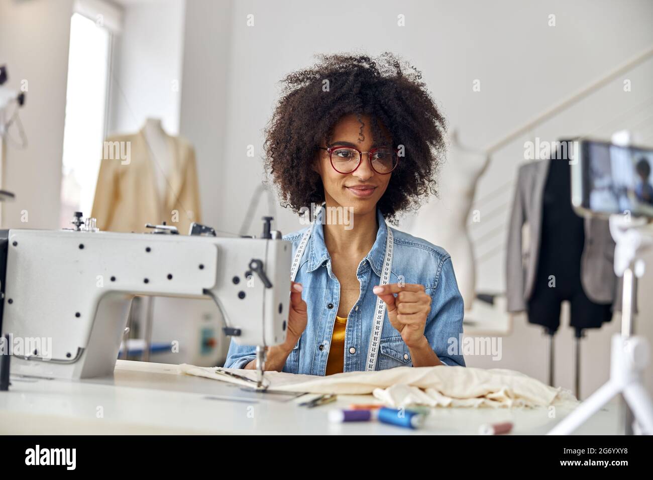 Il dressaker afroamericano tiene i video di ripresa del filo sul posto di lavoro in uno studio spazioso Foto Stock