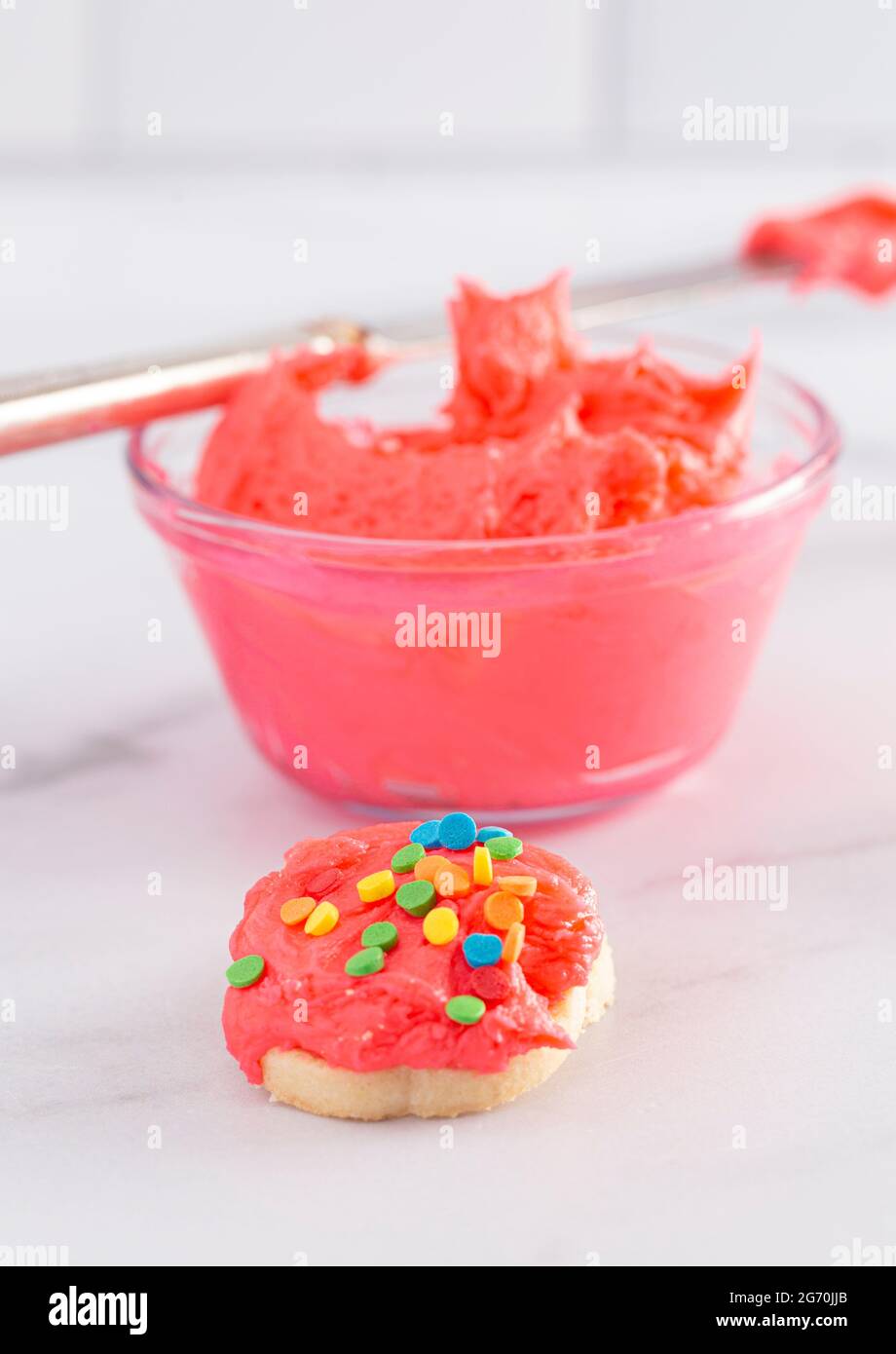 Biscotti decorati con glassa rosa brillante e Rainbow Sprinkles Foto stock  - Alamy