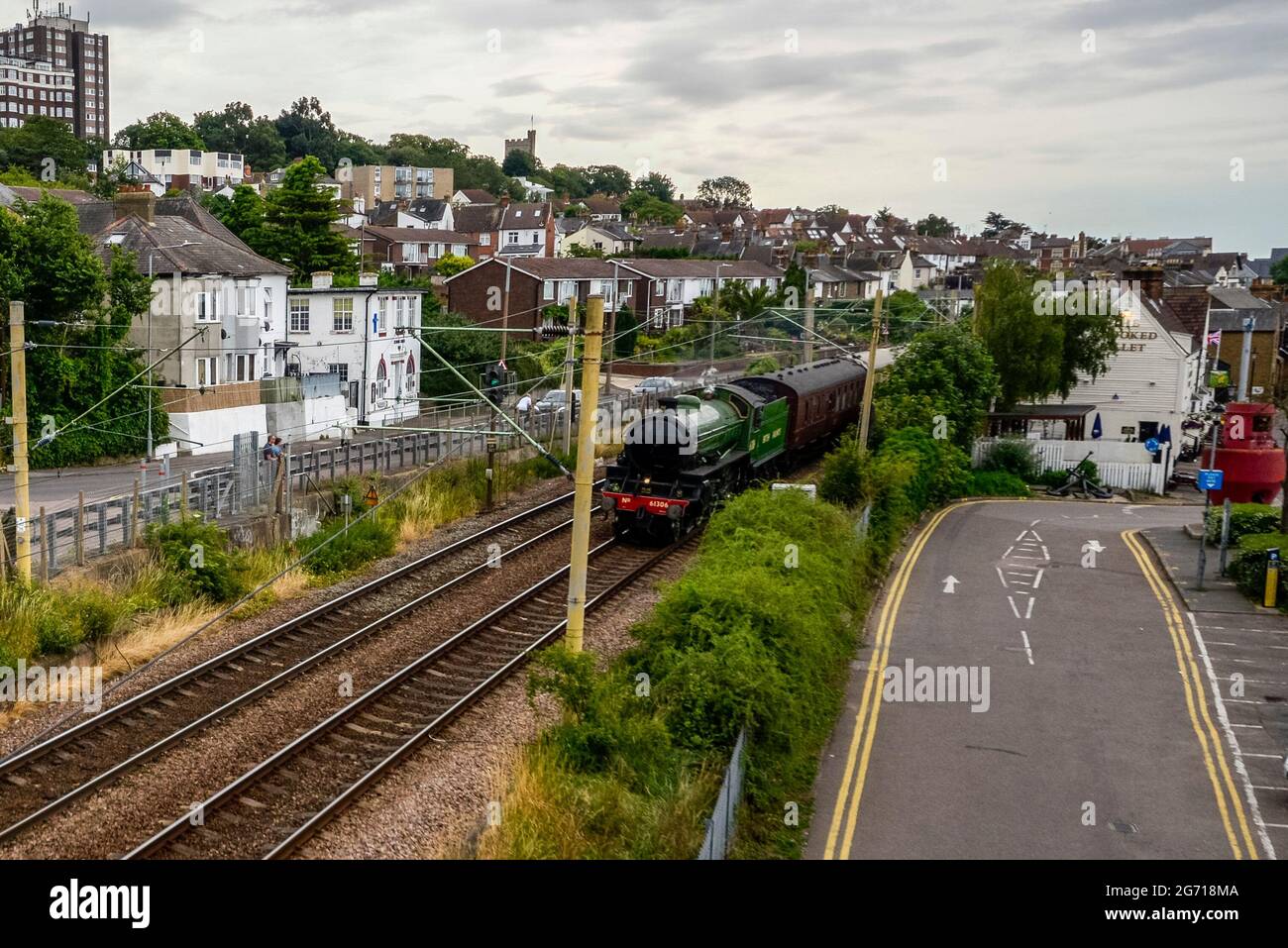 Old Leigh, Leigh on Sea, Essex, Regno Unito. 10 luglio 2021. Un'escursione a vapore 61306 Dreams dalla stazione di Southend Est a Hastings è passata attraverso l'area del vecchio villaggio di pescatori di Leigh on Sea, conosciuta come Old Leigh, trainato dal LNER Thompson Classe B1 ‘M'Ayflower' splendente di livrea verde mela. Lo speciale tour a vapore mattutino viaggerà attraverso Londra prima di dirigersi verso la costa del Sussex orientale Foto Stock