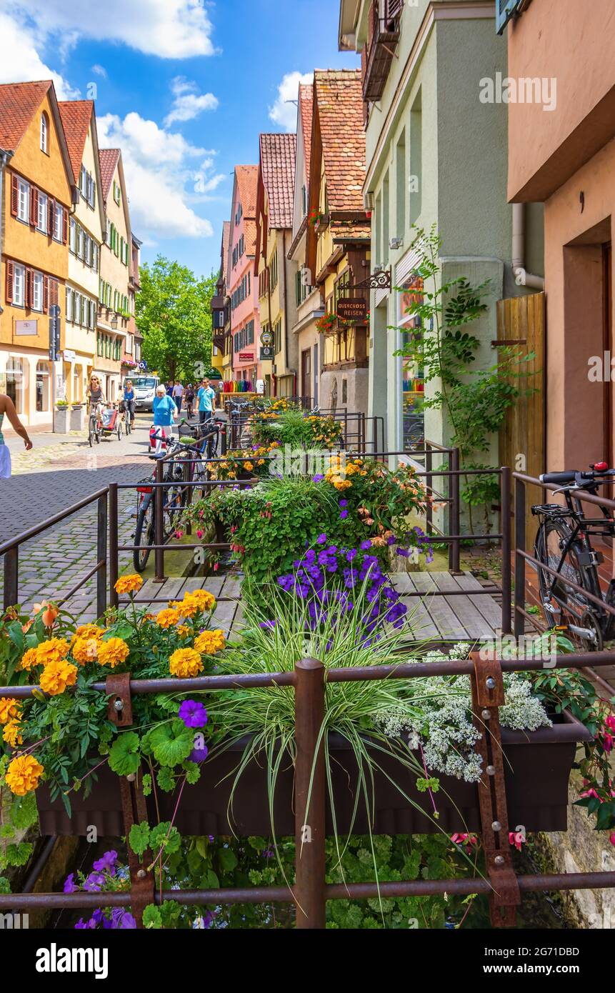 Tübingen, Baden-Württemberg, Germania: Scena di strada su Ammergasse con passanti, negozi e decorazioni floreali colorate. Foto Stock