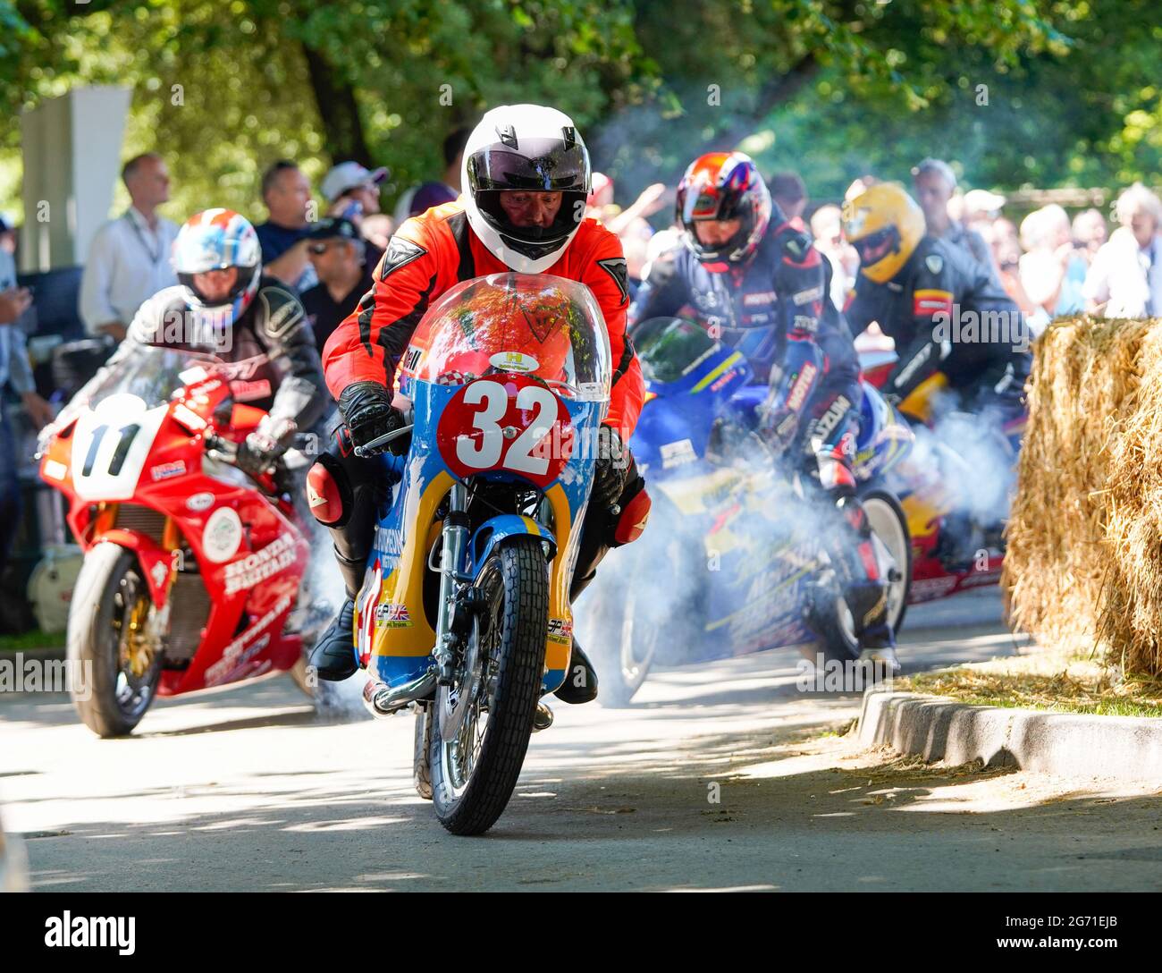 Il numero 32 conduce un pacco di motociclette mentre corrono fuori dal paddock per competere nella salita. Azione dal Goodwood Festival of Speed 2021. Foto Stock