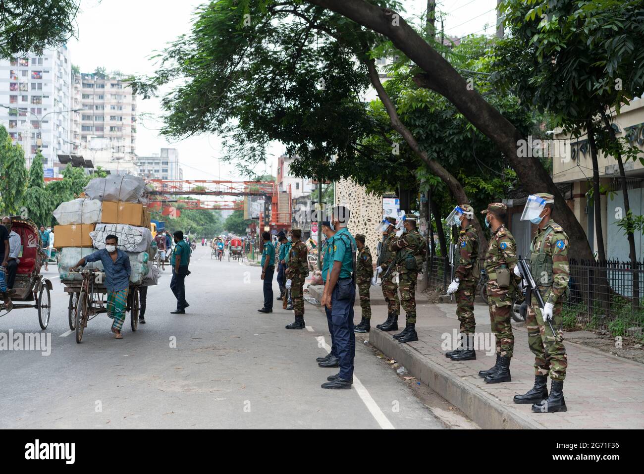Dhaka, Bangladesh. 10 luglio 2021. I funzionari dell'esercito e della polizia si trovano a un posto di controllo mentre controllano i passeggeri durante un blocco. Il governo del Bangladesh ha esteso la sua stretta chiusura con ordini di soggiorno a domicilio per i cittadini fino al 14 luglio, quando le morti quotidiane di coronavirus hanno raggiunto un record. Foto Stock