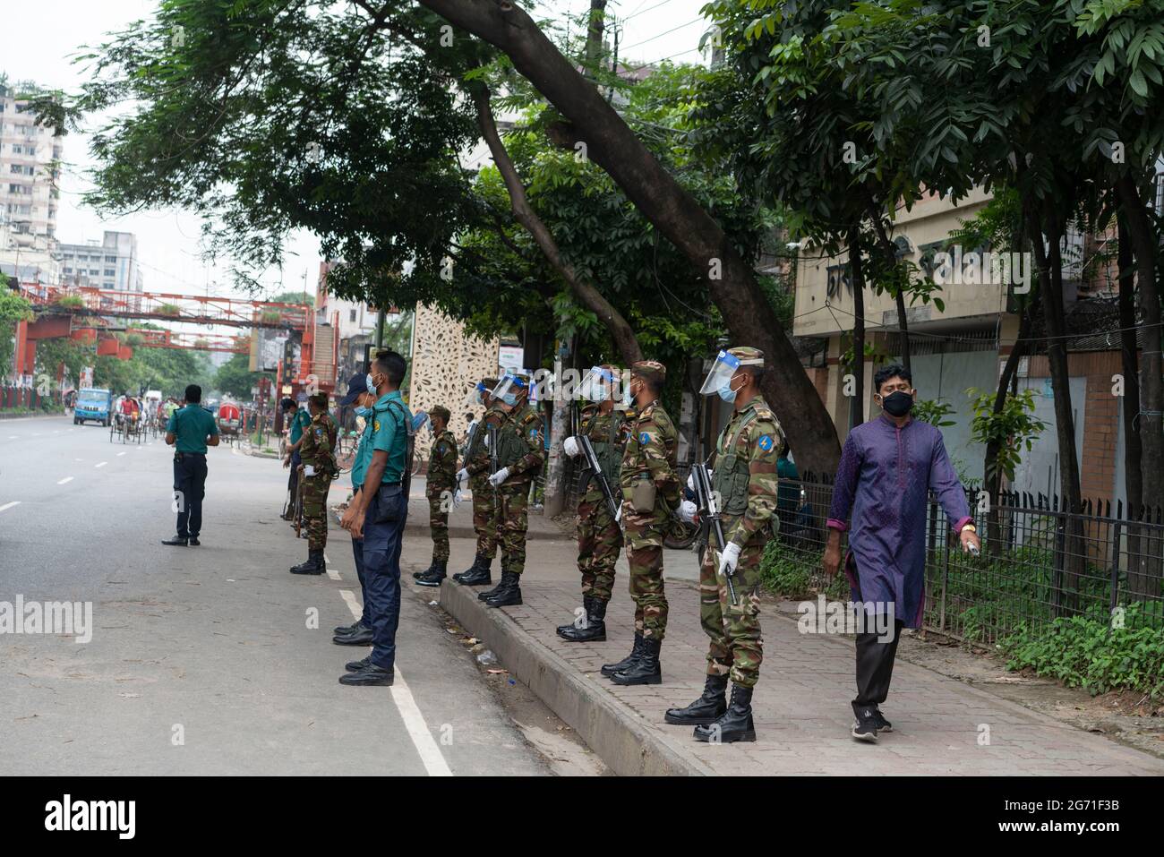 Dhaka, Bangladesh. 10 luglio 2021. I funzionari dell'esercito e della polizia si trovano a un posto di controllo mentre controllano i passeggeri durante un blocco. Il governo del Bangladesh ha esteso la sua stretta chiusura con ordini di soggiorno a domicilio per i cittadini fino al 14 luglio, quando le morti quotidiane di coronavirus hanno raggiunto un record. Foto Stock