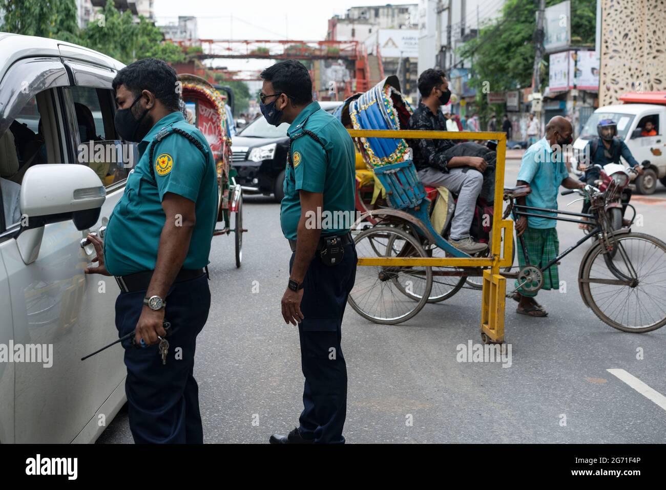 Dhaka, Bangladesh. 10 luglio 2021. I funzionari dell'esercito e della polizia si trovano a un posto di controllo mentre controllano i passeggeri durante un blocco. Il governo del Bangladesh ha esteso la sua stretta chiusura con ordini di soggiorno a domicilio per i cittadini fino al 14 luglio, quando le morti quotidiane di coronavirus hanno raggiunto un record. Foto Stock