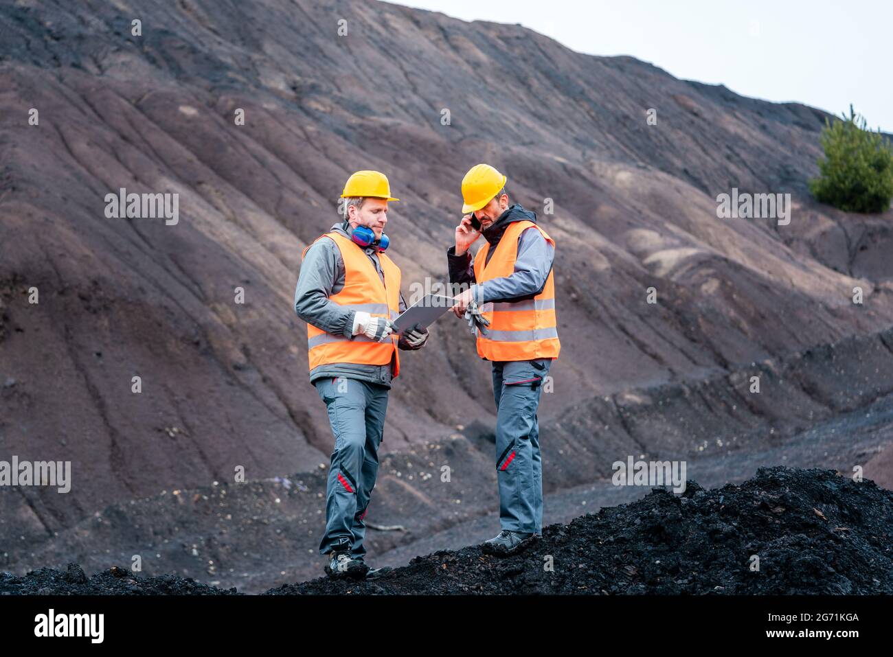 Lavoratori in piedi in open-cast miniera di funzionamento buca Foto Stock