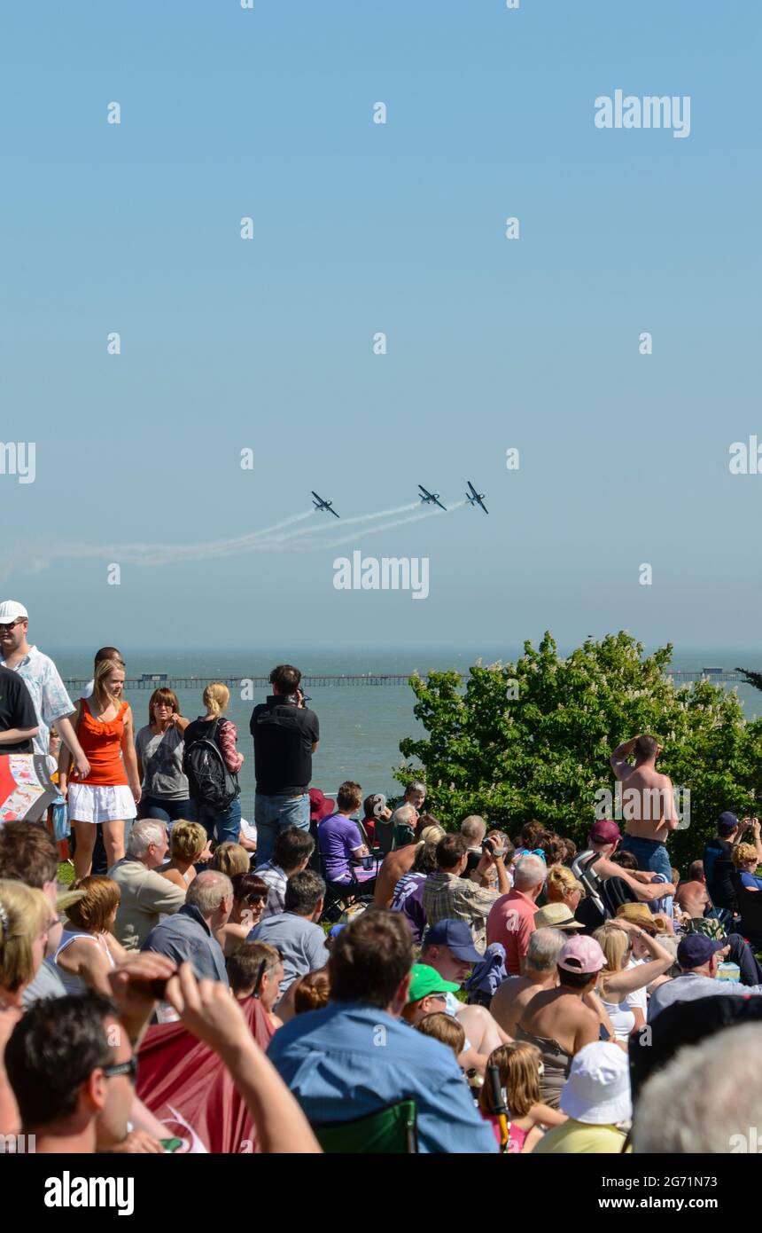 Southend Airshow 2012. Folla sul lungomare con l'esposizione di aerei che volano sull'estuario del Tamigi. Il team di visualizzazione Blades, guardato da persone sulle scogliere Foto Stock