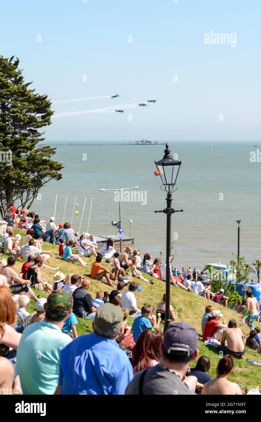 Southend Airshow 2012. Folla sul lungomare con l'esposizione di aerei che volano sull'estuario del Tamigi. Il team di visualizzazione Blades, guardato da persone sulle scogliere Foto Stock