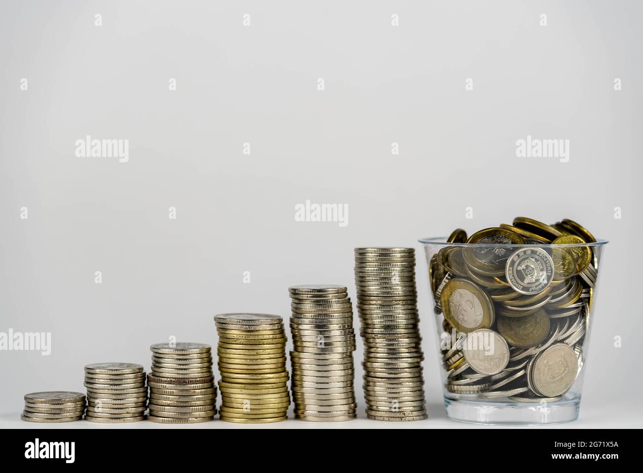 risparmio di denaro, crescita finanziaria delle imprese, budget economico e concetto di investimento. monete d'oro in vaso e monete in pila crescita su sfondo bianco. Foto Stock