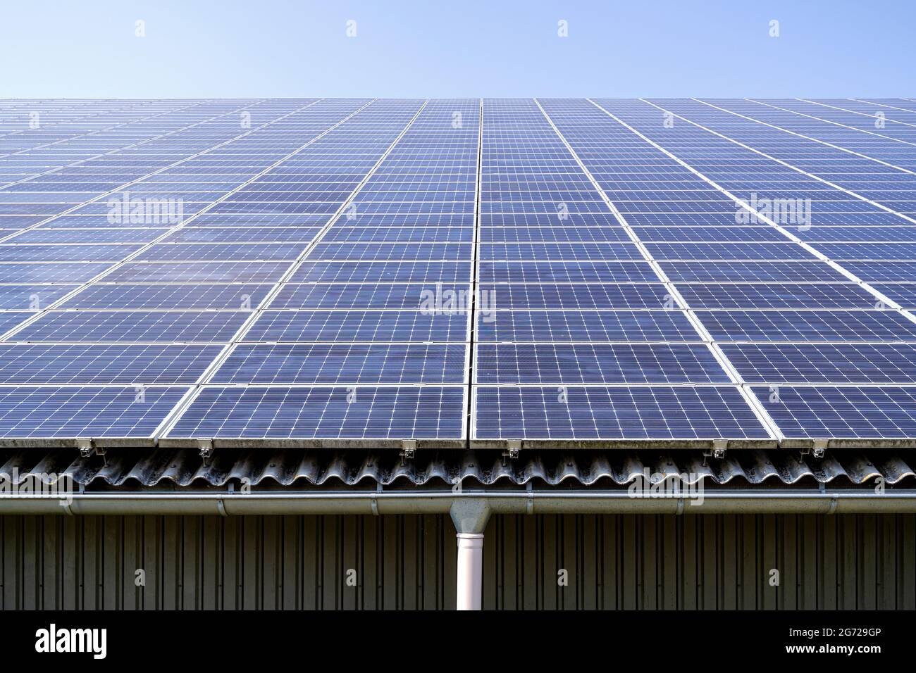 collettori solari montati sul tetto su un grande tetto Foto Stock