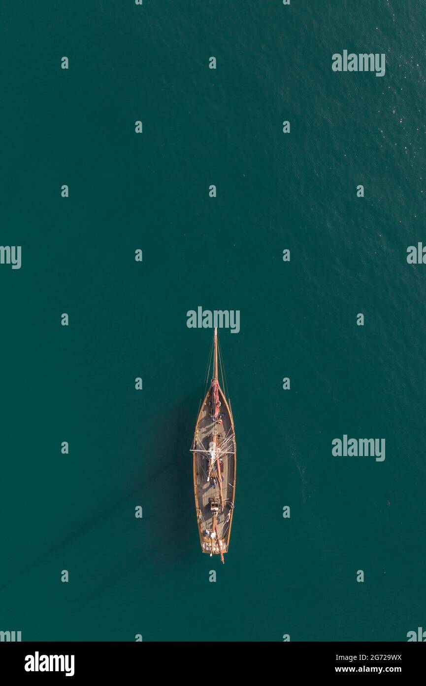 Vista aerea dall'alto di una bella nave a vela ad albero alto che galleggia su un tranquillo oceano turchese con spazio per le copie Foto Stock