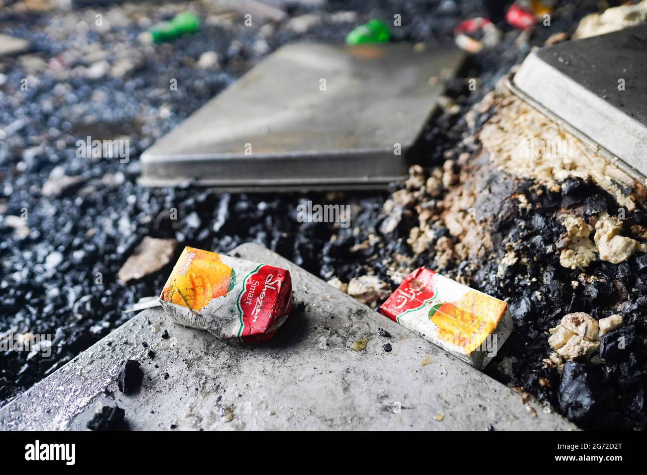 Narayanganj, Bangladesh. 10 luglio 2021. Scatole di succo sono visti presso il sito di un incendio che ha scoppiato il giovedì sera presso la fabbrica Hashem Foods Ltd a Ruppanj, distretto di Narayanganj, alla periferia di Dhaka. Almeno 52 persone sono state trovate morte, 25 altre ferite e molte sono temute intrappolate dopo un incendio massiccio infuriato attraverso una fabbrica, la causa dell'incendio che ha avuto origine a un piano terra di un edificio a più piani della fabbrica non è ancora conosciuta. Credit: SOPA Images Limited/Alamy Live News Foto Stock