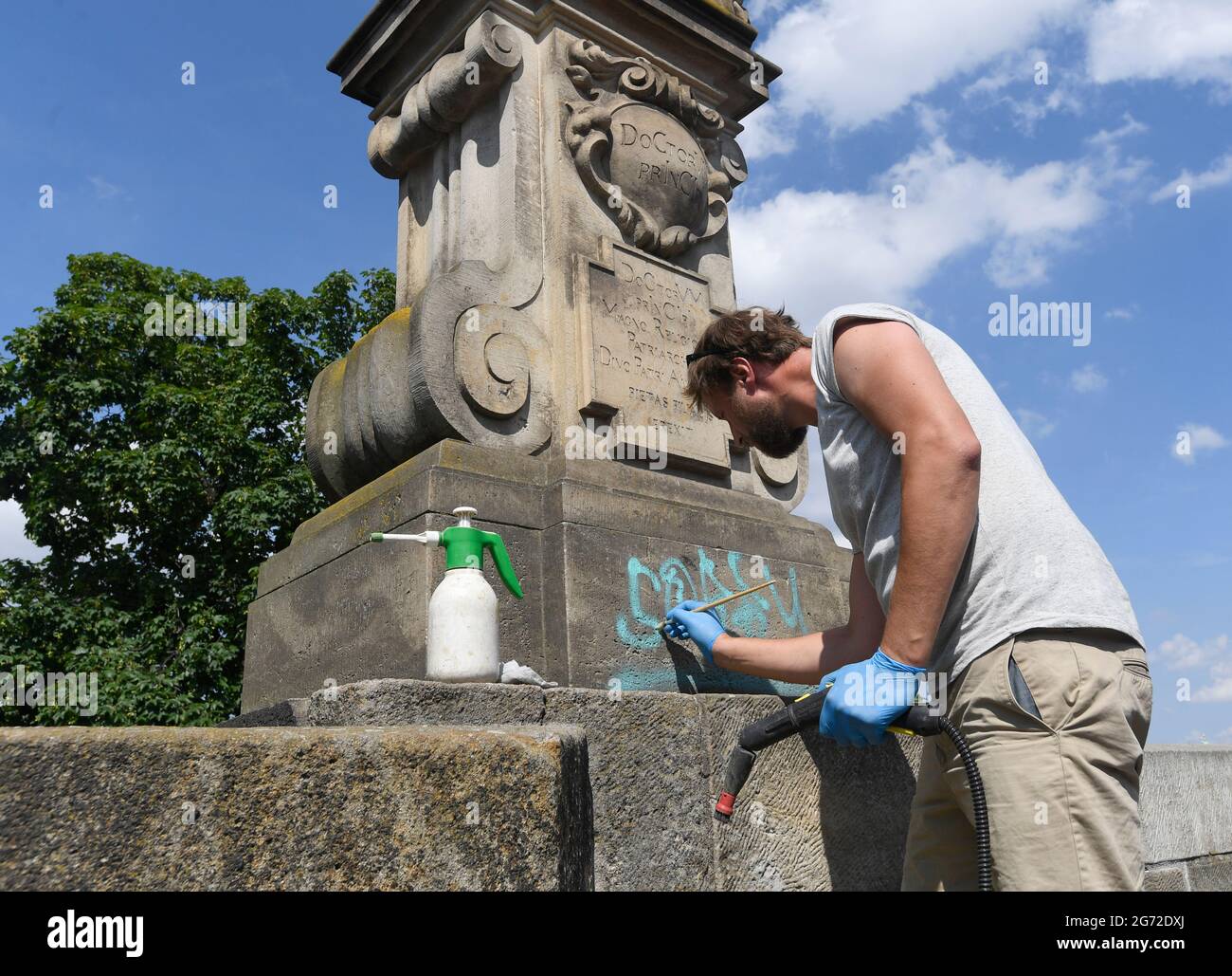 Praga, Repubblica Ceca. 10 luglio 2021. Il restauratore Jakub Tluchor iniziò a rimuovere graffiti dal Ponte Carlo a Praga, Repubblica Ceca, il 10 luglio 2021. Le iscrizioni blu in inglese sono sulla parete sul lato destro del ponte verso il Castello di Praga dal giorno precedente. (CTK Photo/Michal Krumphanzl) Credit: CTK/Alamy Live News Foto Stock