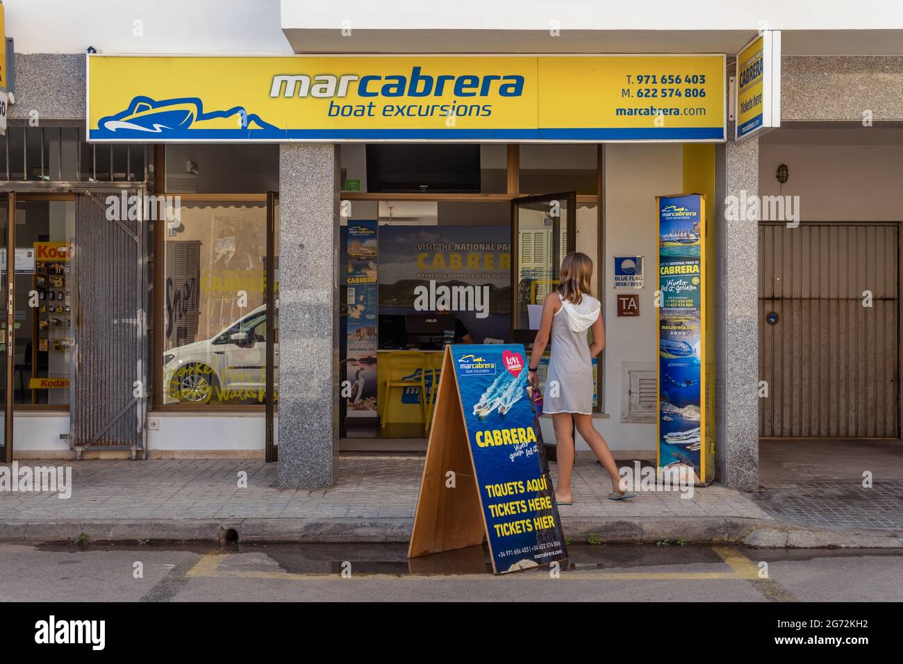 Colonia de Sant Jordi, Spagna; luglio 02 2021: Un negozio che vende biglietti per gite turistiche in barca all'isola di Cabrera, dove una donna sta cercando interno Foto Stock