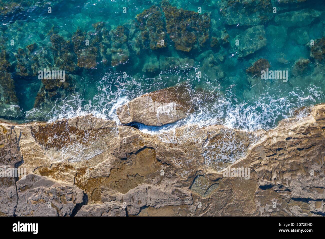 Onde di mare che si infrangono su una riva rocciosa, sfondo naturale e aereo Foto Stock