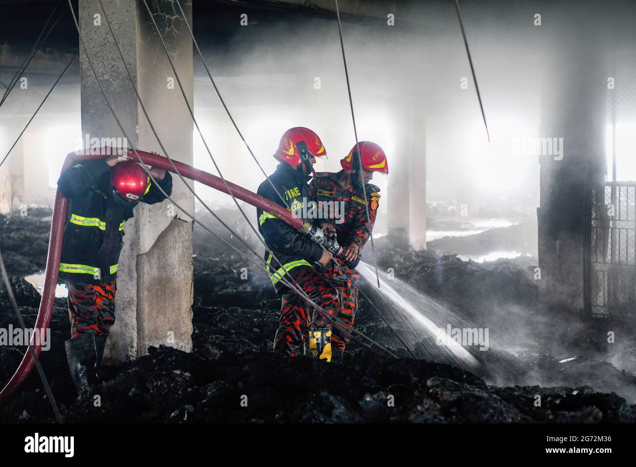 Dhaka, Bangladesh. 10 luglio 2021. I vigili del fuoco lavorano sul luogo di un incendio scoppiato giovedì sera presso la fabbrica Hashem Foods Ltd a Ruppanj, distretto di Narayanganj, alla periferia di Dhaka. Almeno 52 persone sono state trovate morte, 25 altre ferite e molte sono temute intrappolate dopo un incendio massiccio infuriato attraverso una fabbrica, la causa dell'incendio che ha avuto origine a un piano terra di un edificio a più piani della fabbrica non è ancora conosciuta. (Foto di Piyas Biswas/SOPA Images/Sipa USA) Credit: Sipa USA/Alamy Live News Foto Stock