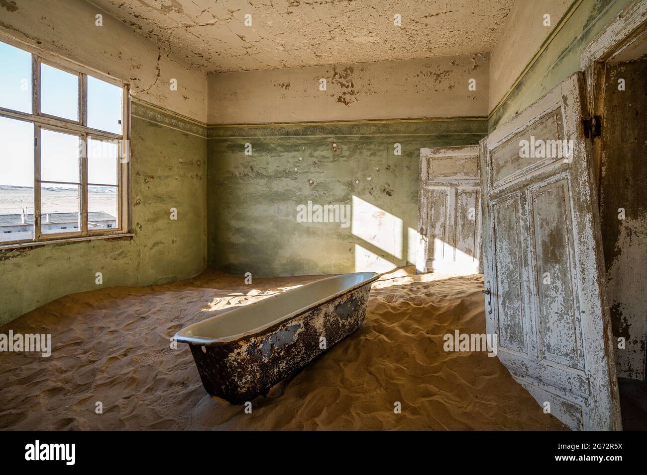 L'edificio abbandonato è stato preso in consegna dalla sabbia incrostata nella vecchia città mineraria di Kolmanskop vicino a Luderitz, Namib Desert, Namibia. Foto Stock