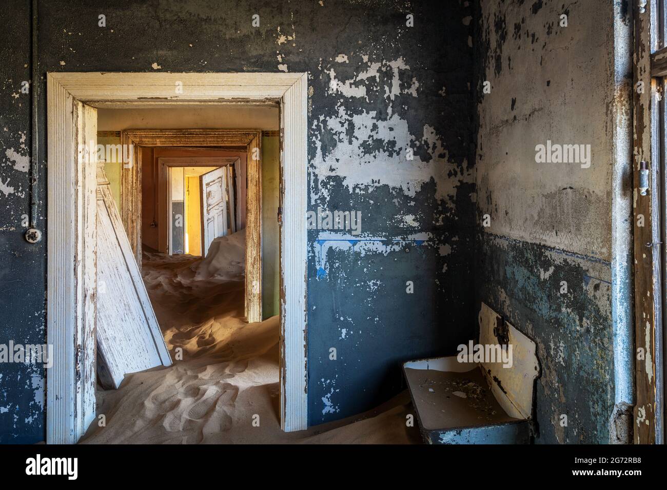 L'edificio abbandonato è stato ripreso dalla sabbia incrollabile nella città fantasma di Kolmanskop vicino a Luderitz, nel deserto del Namib, in Namibia. Foto Stock