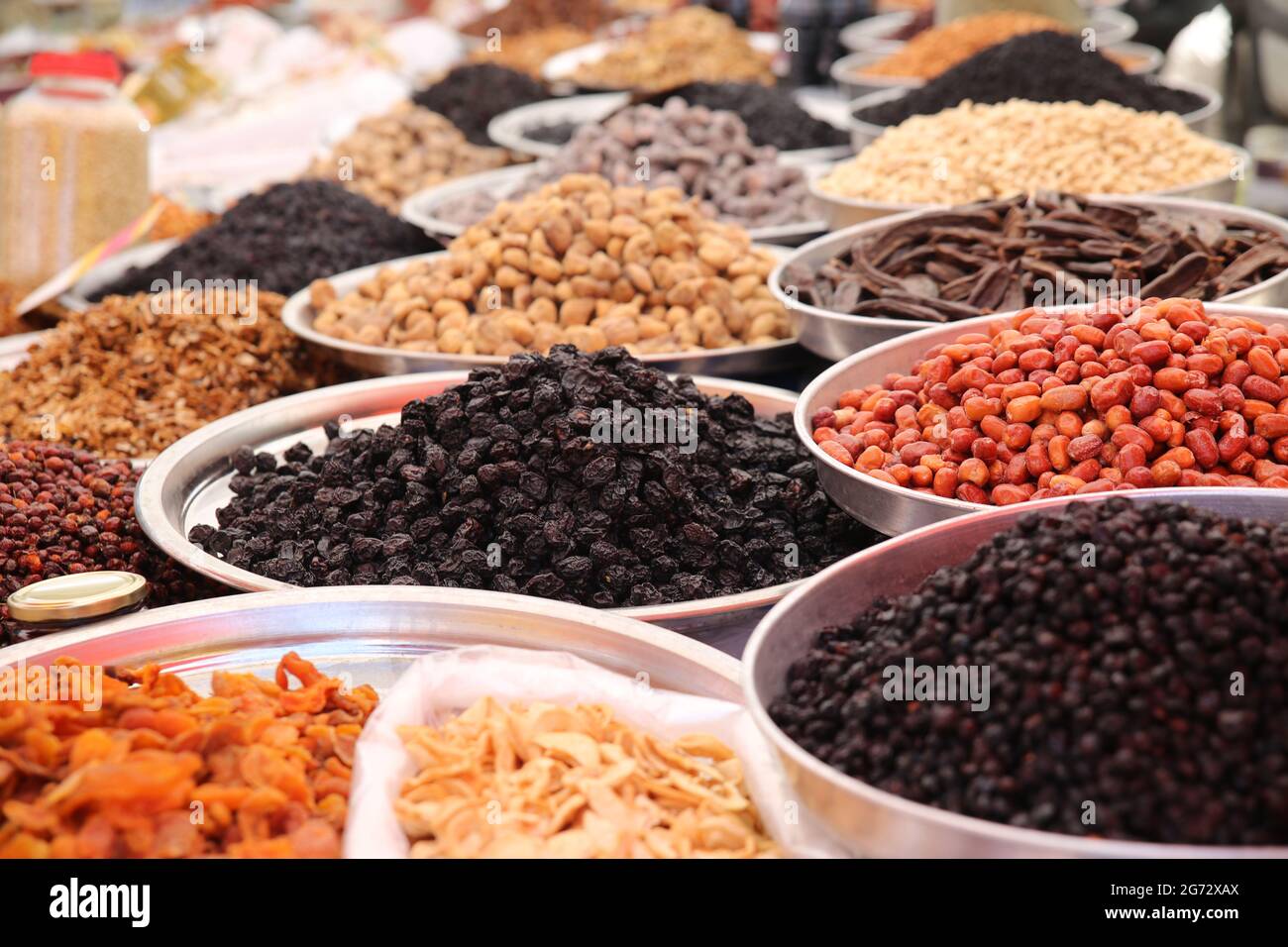 Primo piano di una varietà di uva passa secca e sultanina in esposizione in grandi vassoi di metallo in un bazaar. Foto Stock