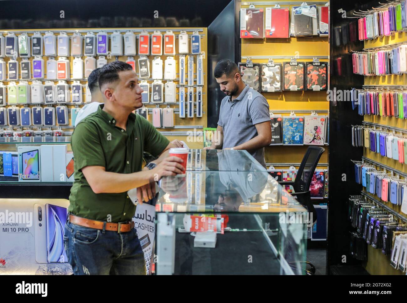 Gaza, Palestina. 10 luglio 2021. Un palestinese lavora in un negozio di telefonia. Con l'aumento dei prezzi, i tassi di disoccupazione e la mancanza di opportunità di lavoro a Gaza, un numero crescente di famiglie sta affrontando la povertà dopo aver perso il lavoro durante l'assedio e la guerra nella striscia di Gaza. Credit: SOPA Images Limited/Alamy Live News Foto Stock Gaza, Palestina. 10 luglio 2021. Un palestinese lavora in un negozio di telefonia. Con l'aumento dei prezzi, i tassi di disoccupazione e la mancanza di opportunità di lavoro a Gaza, un numero crescente di famiglie sta affrontando la povertà dopo aver perso il lavoro durante l'assedio e la guerra nella striscia di Gaza. Credit: SOPA Images Limited/Alamy Live News Foto Stock