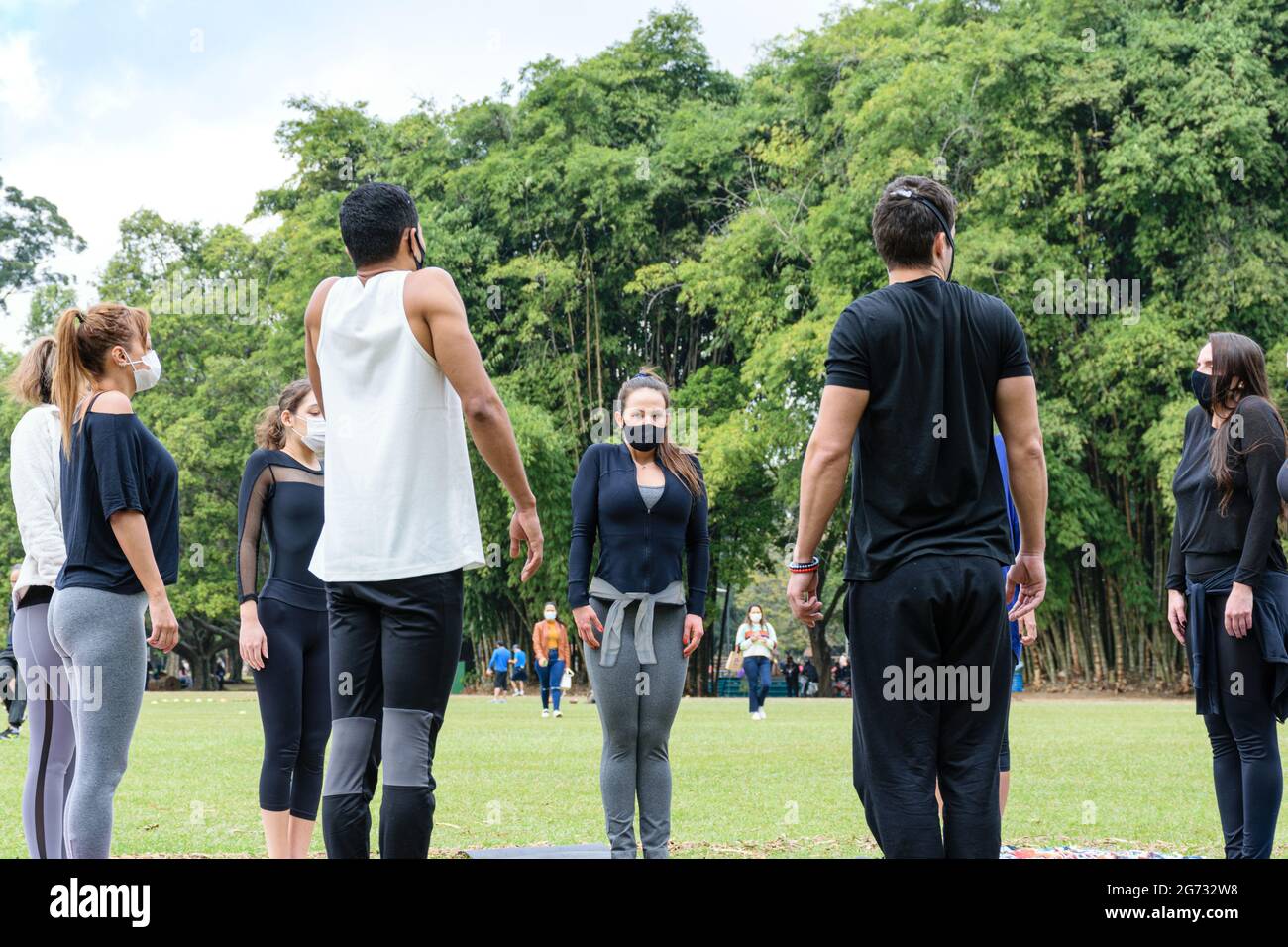 San Paolo, San Paolo, Brasile - Luglio, 04 2021: Giovane brasiliano di 28 anni che dà lezioni di yoga ad un piccolo gruppo nel parco pubblico Ibirapuera. Foto Stock