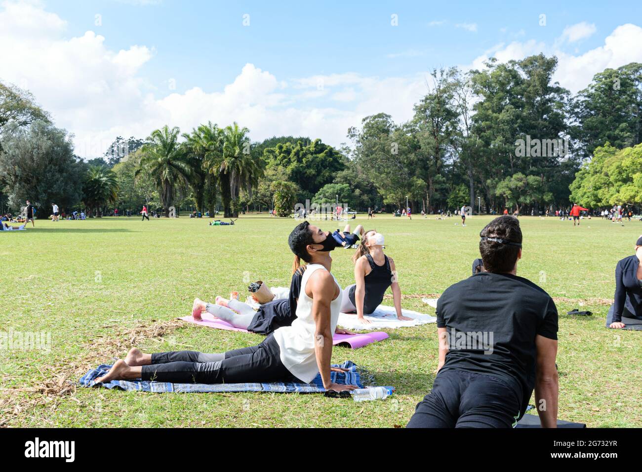 Sao Paulo, Sao Paulo, Brasile - Luglio, 04 2021: Giovane brasiliano di 28 anni che dà una lezione di yoga di gruppo nella posizione del cane rivolta verso l'alto. Foto Stock