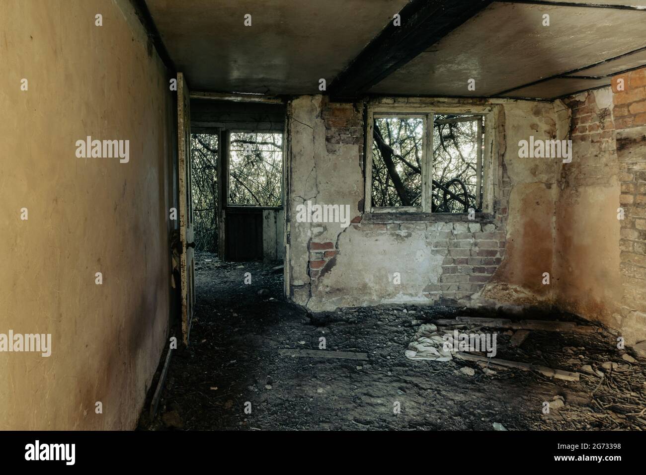 Una camera decadente in una casa abbandonata in rovina. Con porte e finestre rotte. Foto Stock