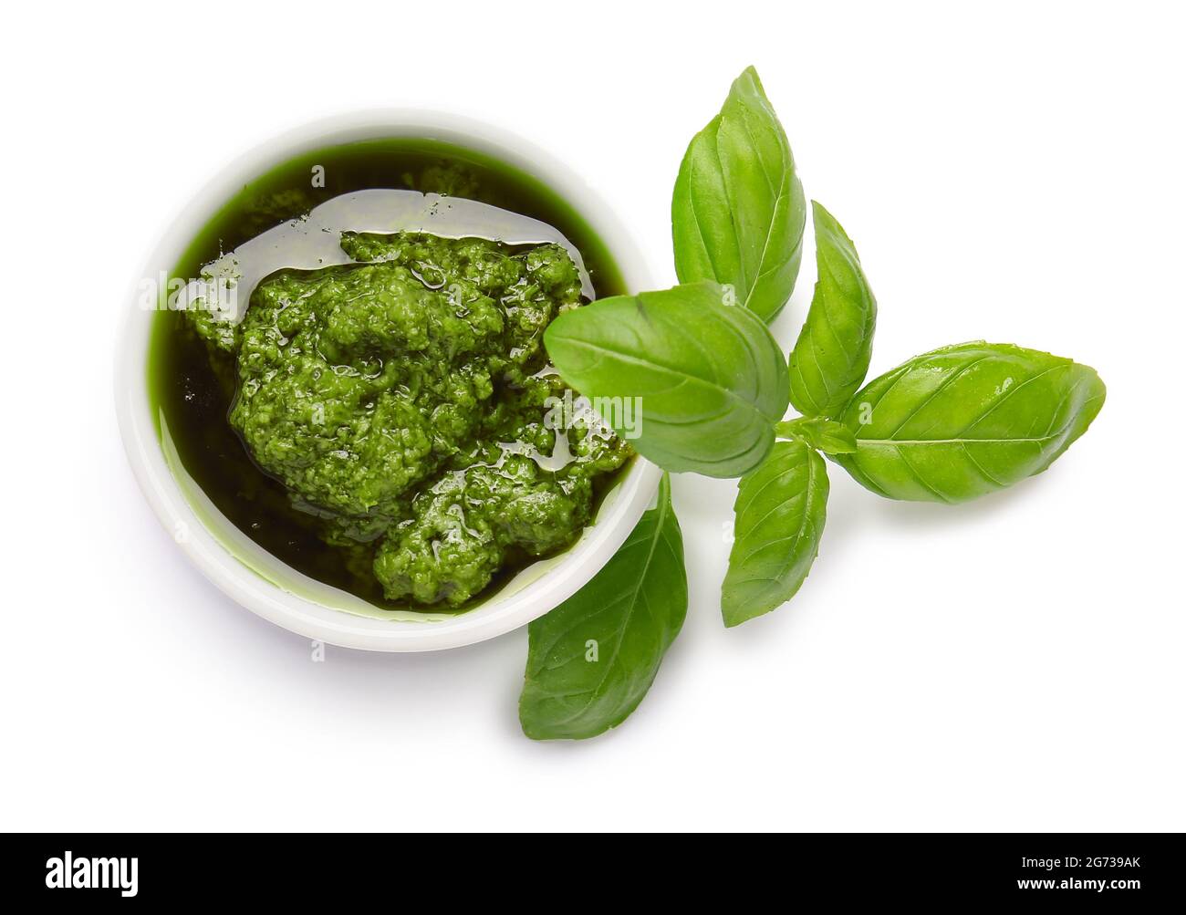 Ciotola con salsa di pesto fresco e foglie di basilico su sfondo bianco  Foto stock - Alamy