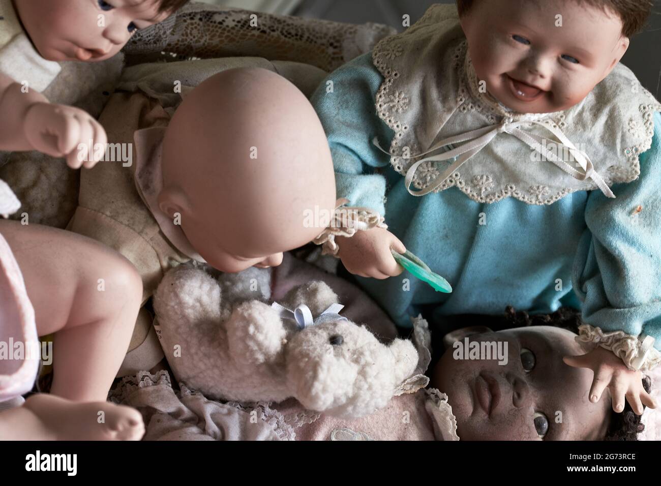 Bambole bambini ragazzi e ragazze con un orsacchiotto, primo piano di giocattoli vintage in ceramica Foto Stock