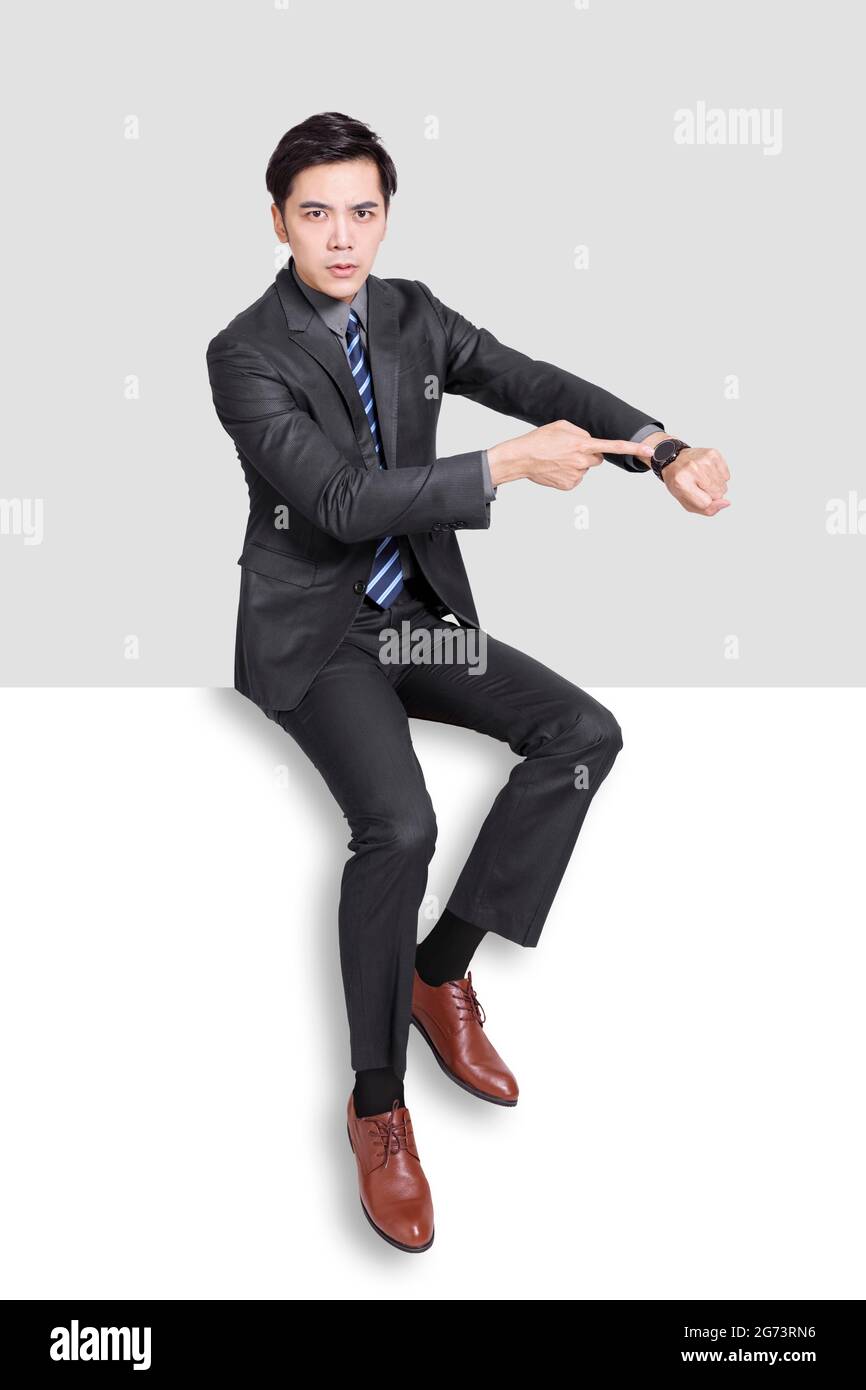 Il giovane uomo d'affari punta le mani al suo orologio. Foto Stock