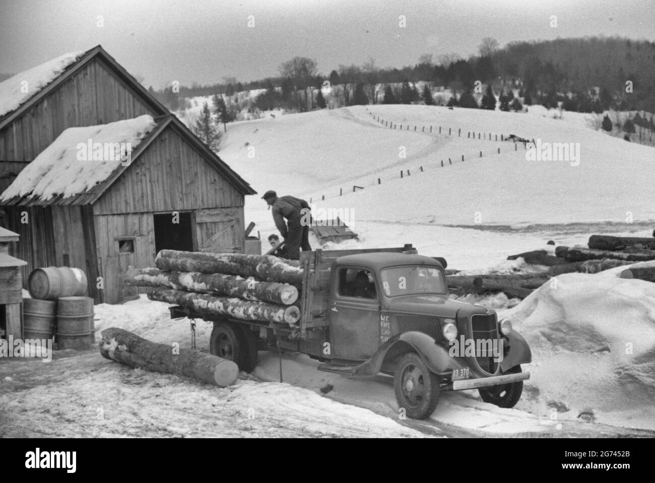 Camion raccogliere tronchi da prendere al mulino in fattoria vicino Waterbury, Vermont, circa 1940 Foto Stock