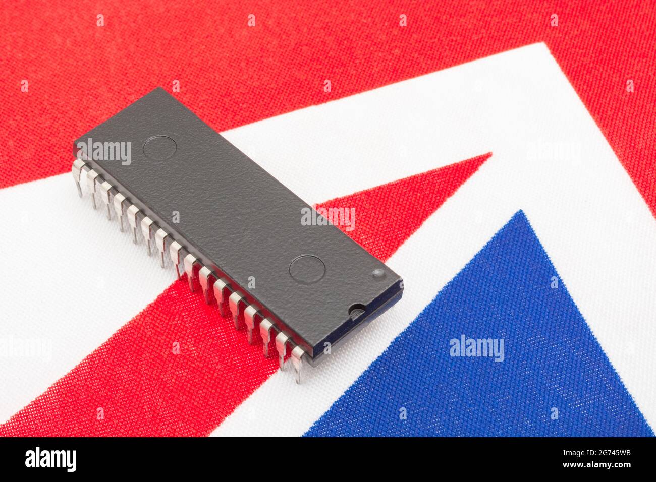 Immagine ravvicinata del circuito integrato / chip EPROM su un piccolo flag Union Jack britannico. Per carenze di semiconduttori nel Regno Unito, dipendenza da chip nel Regno Unito, Start-up di chip nel Regno Unito. Foto Stock