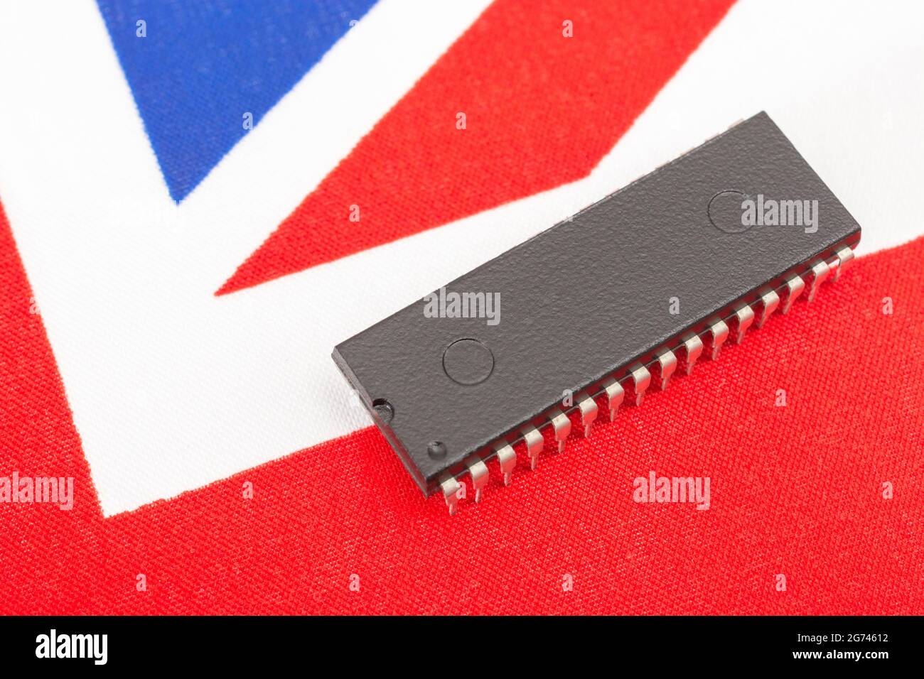 Immagine ravvicinata del circuito integrato / chip EPROM su un piccolo flag Union Jack britannico. Per carenze di semiconduttori nel Regno Unito, dipendenza da chip nel Regno Unito, Start-up di chip nel Regno Unito. Foto Stock