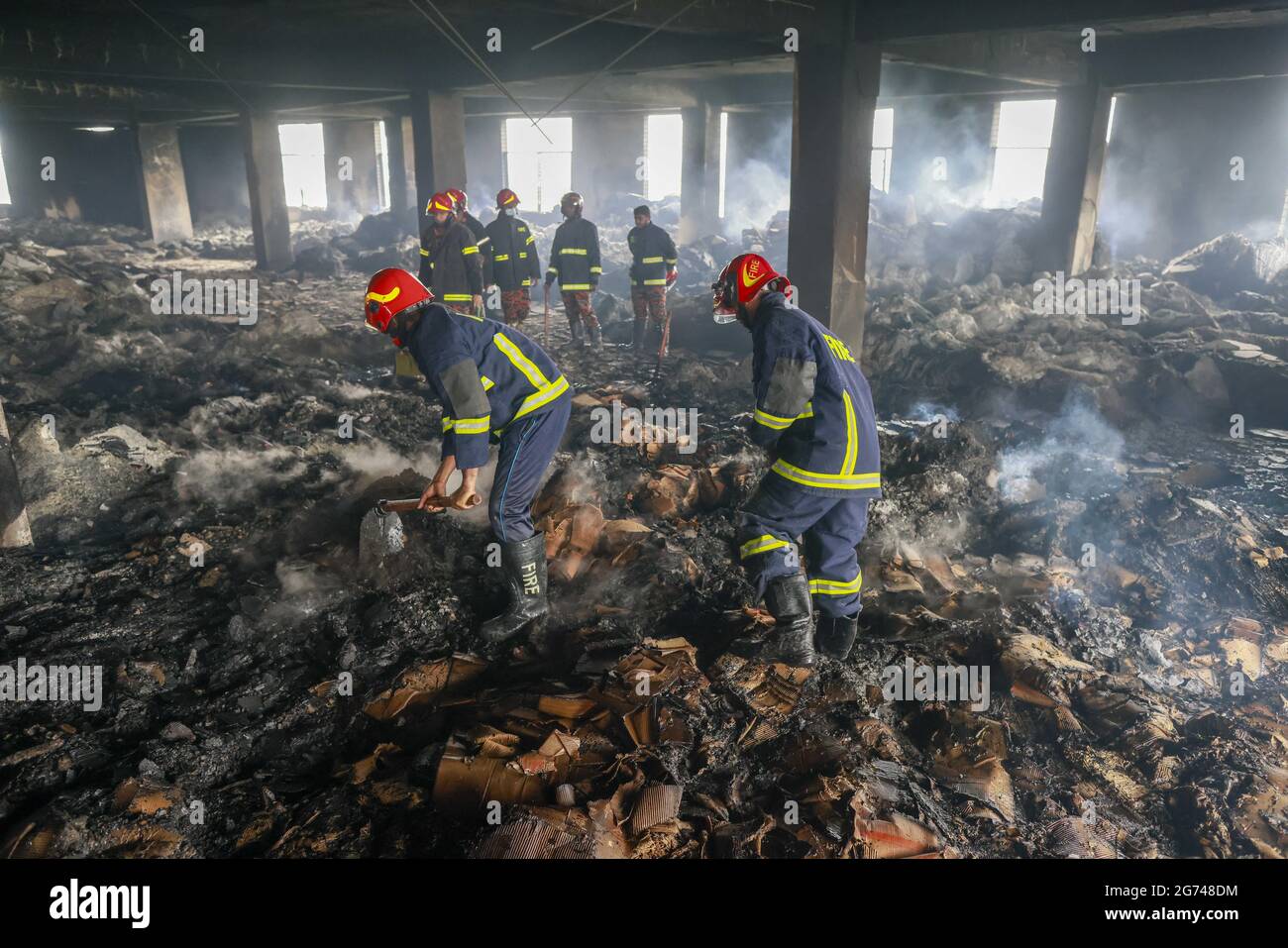 I vigili del fuoco lavorano sul luogo di un incendio scoppiato giovedì sera presso la fabbrica Hashem Foods Ltd a Ruppanj, Narayanganj, alla periferia di Dacca, il 10 luglio 2021. Il proprietario della fabbrica di trasformazione alimentare in Bangladesh è stato arrestato sabato per omicidio a causa di un incendio che ha ucciso 52 persone intrappolate all'interno dell'edificio, ha detto la polizia. La fabbrica a sei piani fuori dalla capitale Dhaka è stata costruita senza permesso, secondo la polizia che ha detto che non aveva uscite di emergenza antincendio e mancava di adeguate misure di sicurezza. Foto di Suvra Kanti Das/ABACAPRESS.COM Foto Stock