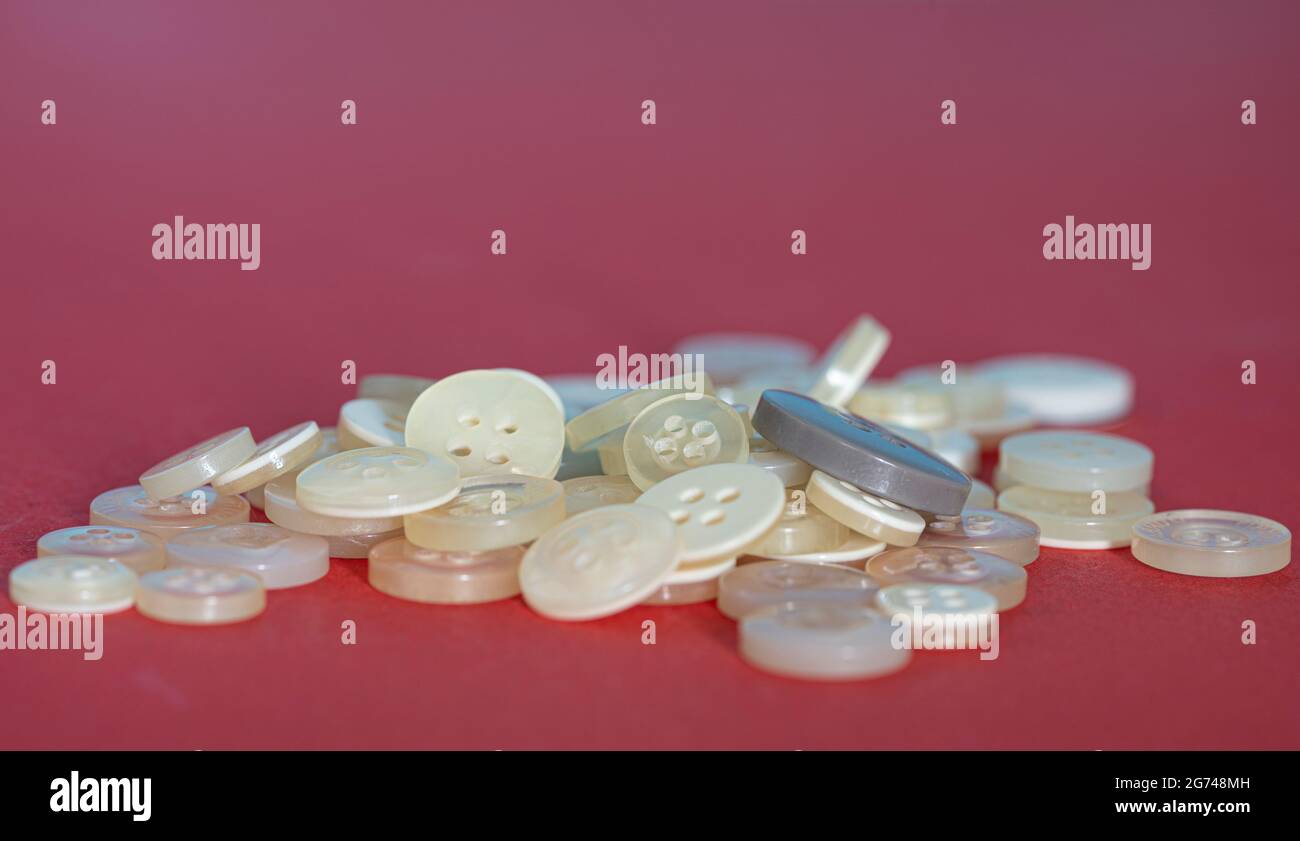 Bottoni di diverse dimensioni e sfumature di bianco. Punti di messa a fuoco selettivi. Sfondo sfocato Foto Stock