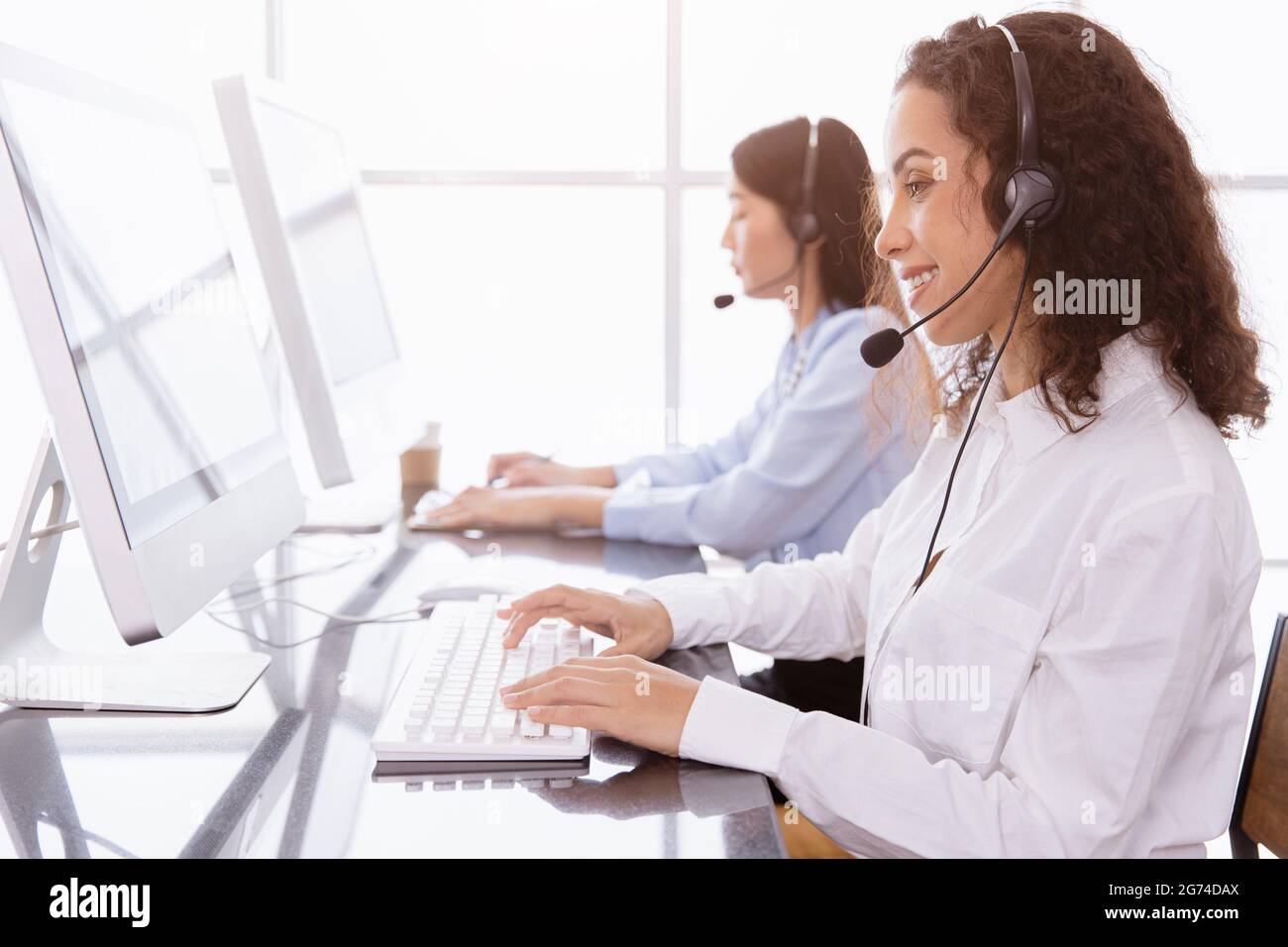 Il personale del call center lavora chiamando la hotline dell'helpdesk o l'agente telesale, il supporto clienti è felice di lavorare con il sorriso in ufficio. Foto Stock