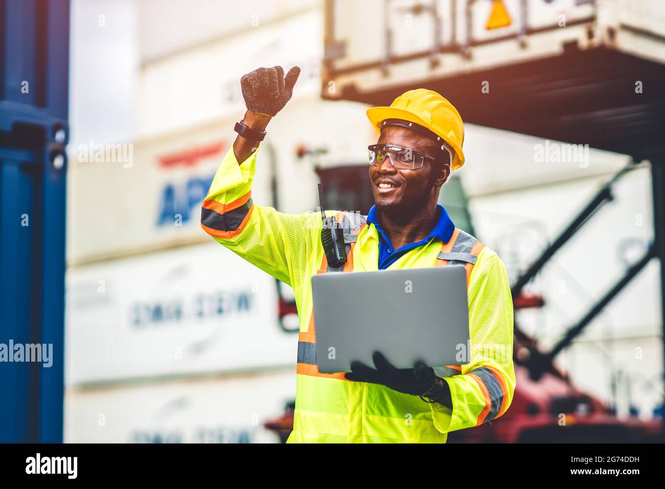 Black African lavoratore felice che lavora nella spedizione logistica con computer portatile controllo di carico container al porto di carico. Importazione esportazione settore del trasporto marittimo Foto Stock