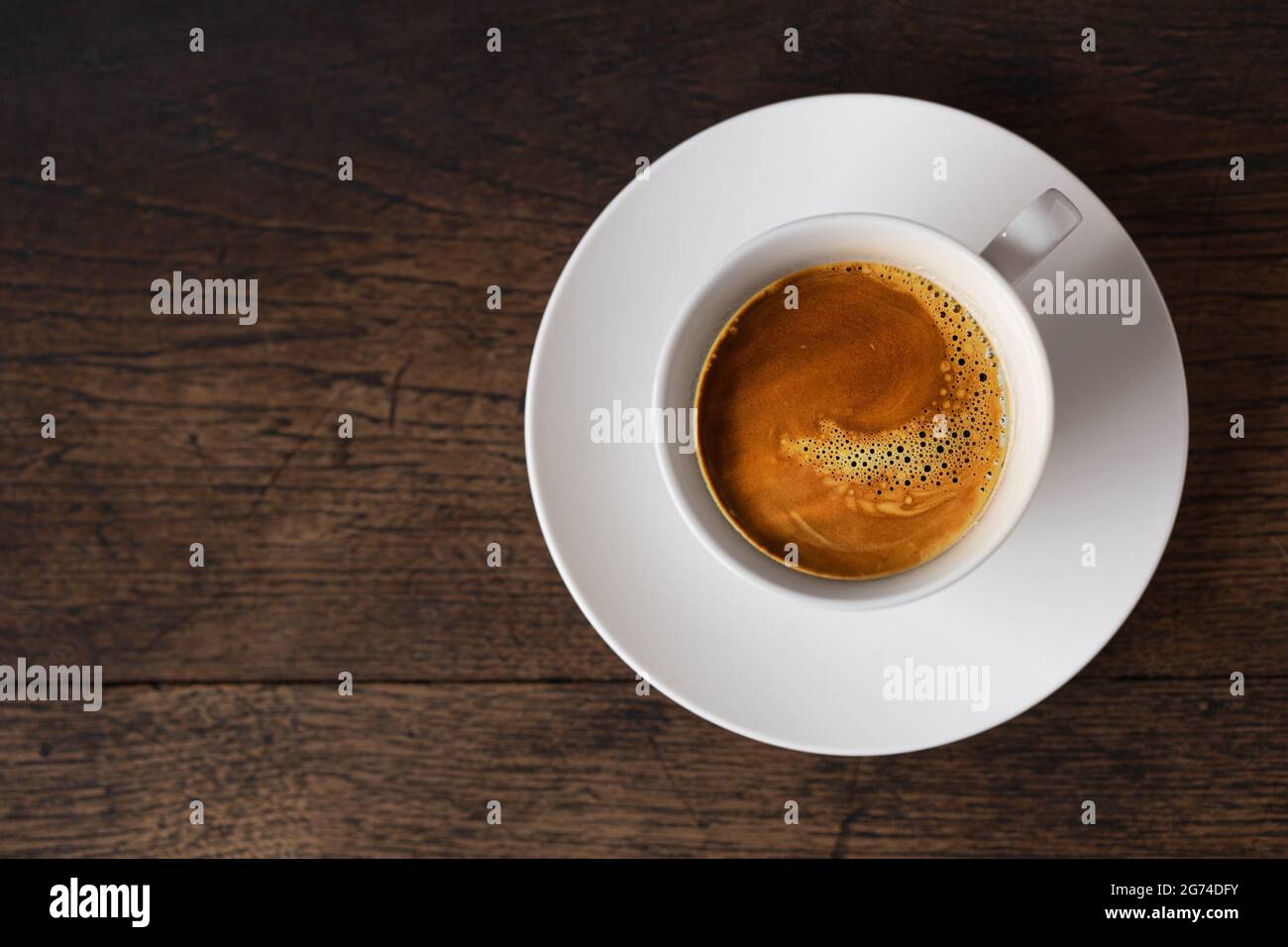 caffè espresso dark rost su tazza bianca su sfondo vecchio tavolo di legno con spazio per la copia. Foto Stock