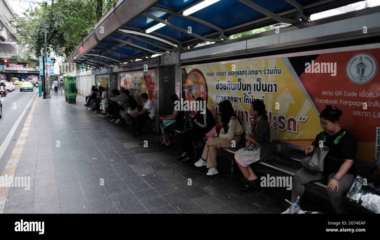 Persone che aspettano alla fermata dell'autobus sulla Sukhumvit Road Sukhumvit Road Bangkok Thailandia Foto Stock