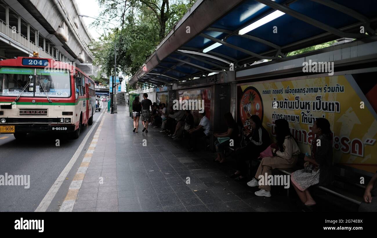 Persone che aspettano alla fermata dell'autobus sulla Sukhumvit Road Sukhumvit Road Bangkok Thailandia Foto Stock