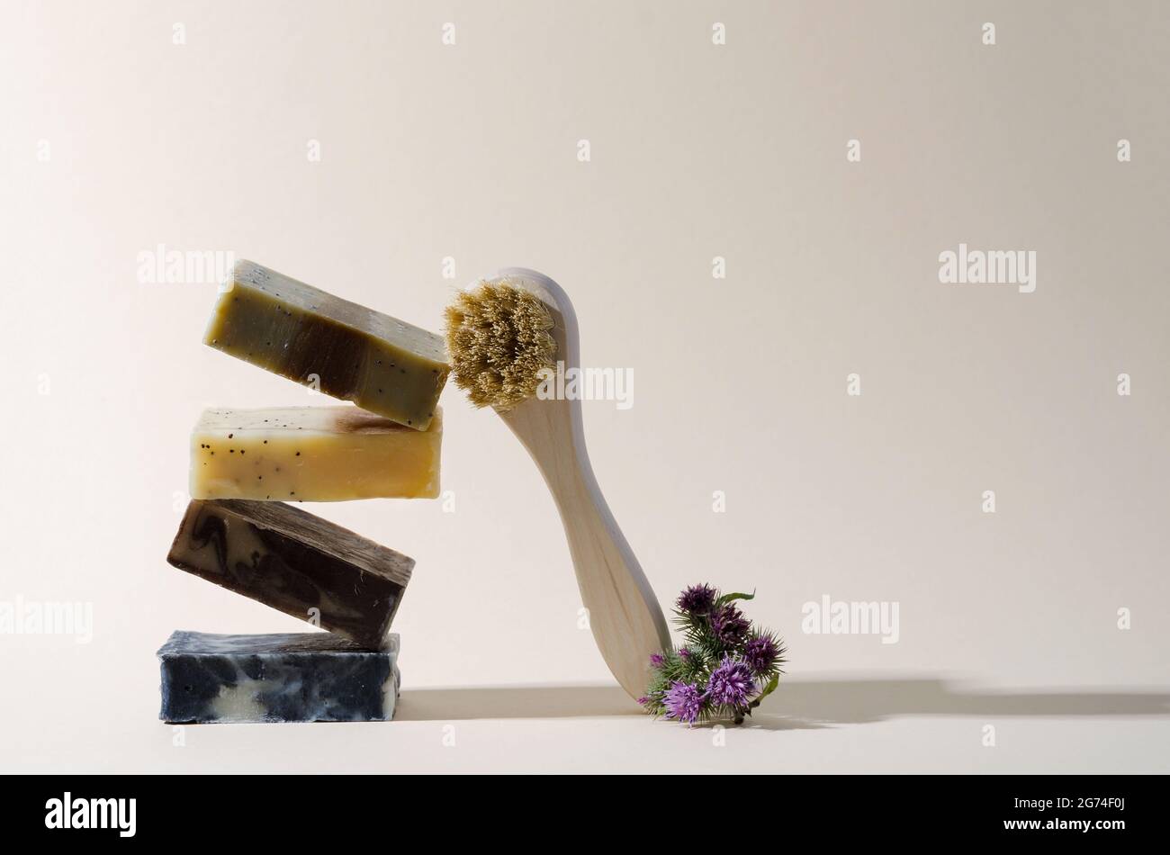 Saponetta equilibrante da prodotti naturali e spazzola per peeling su sfondo beige. Il concetto di prodotti per la cura del viso e della mano con spazio di copiatura Foto Stock