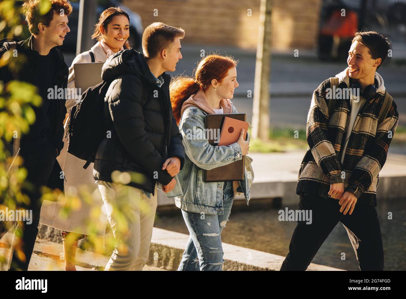 gli studenti universitari si divertiranno all'aperto dopo la lezione. Giovani che camminano fuori dopo la lezione. Foto Stock