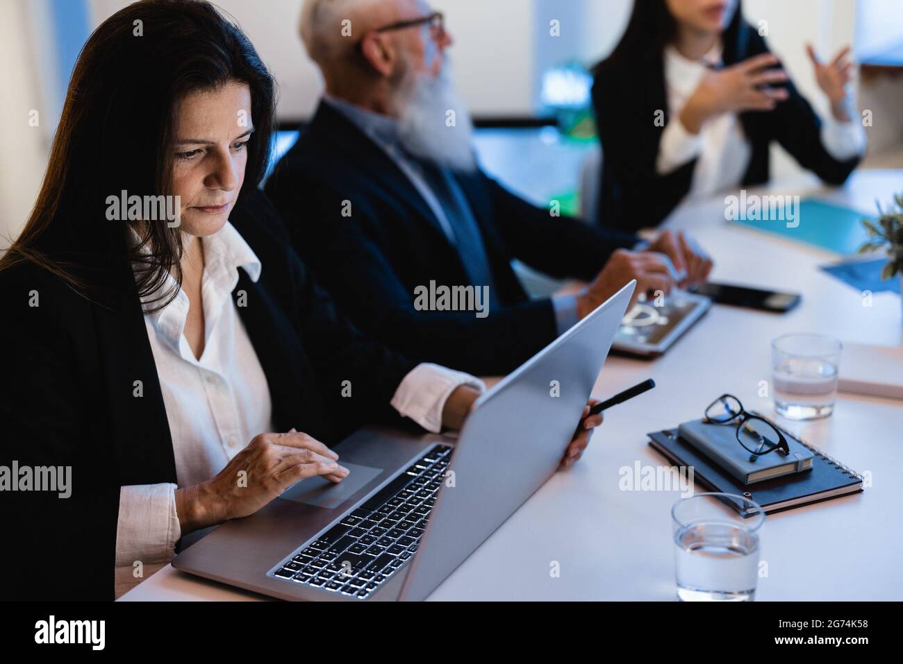 Lavoro di squadra che fa riunione all'interno della stanza della banca - fuoco sul viso maturo della donna Foto Stock