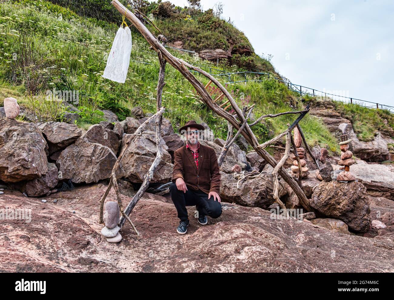 James Craig Page, organizzatore del Campionato europeo di Stacking della pietra con sculture di roccia sulla spiaggia Eye Cave, Dunbar, East Lothian, Scozia, Regno Unito Foto Stock