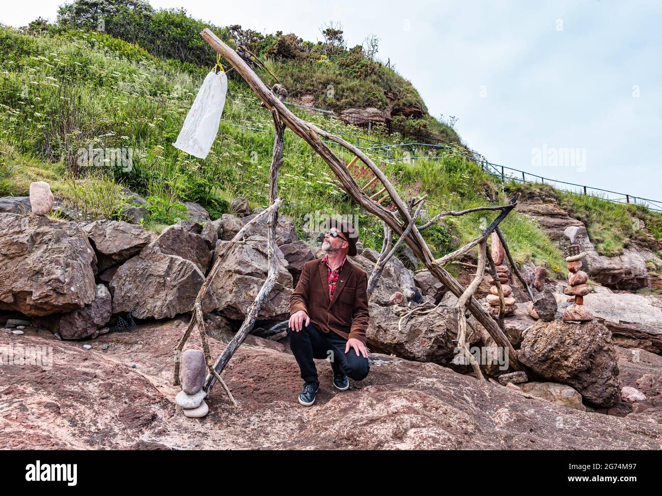 James Craig Page, organizzatore del Campionato europeo di Stacking della pietra con sculture di roccia sulla spiaggia Eye Cave, Dunbar, East Lothian, Scozia, Regno Unito Foto Stock