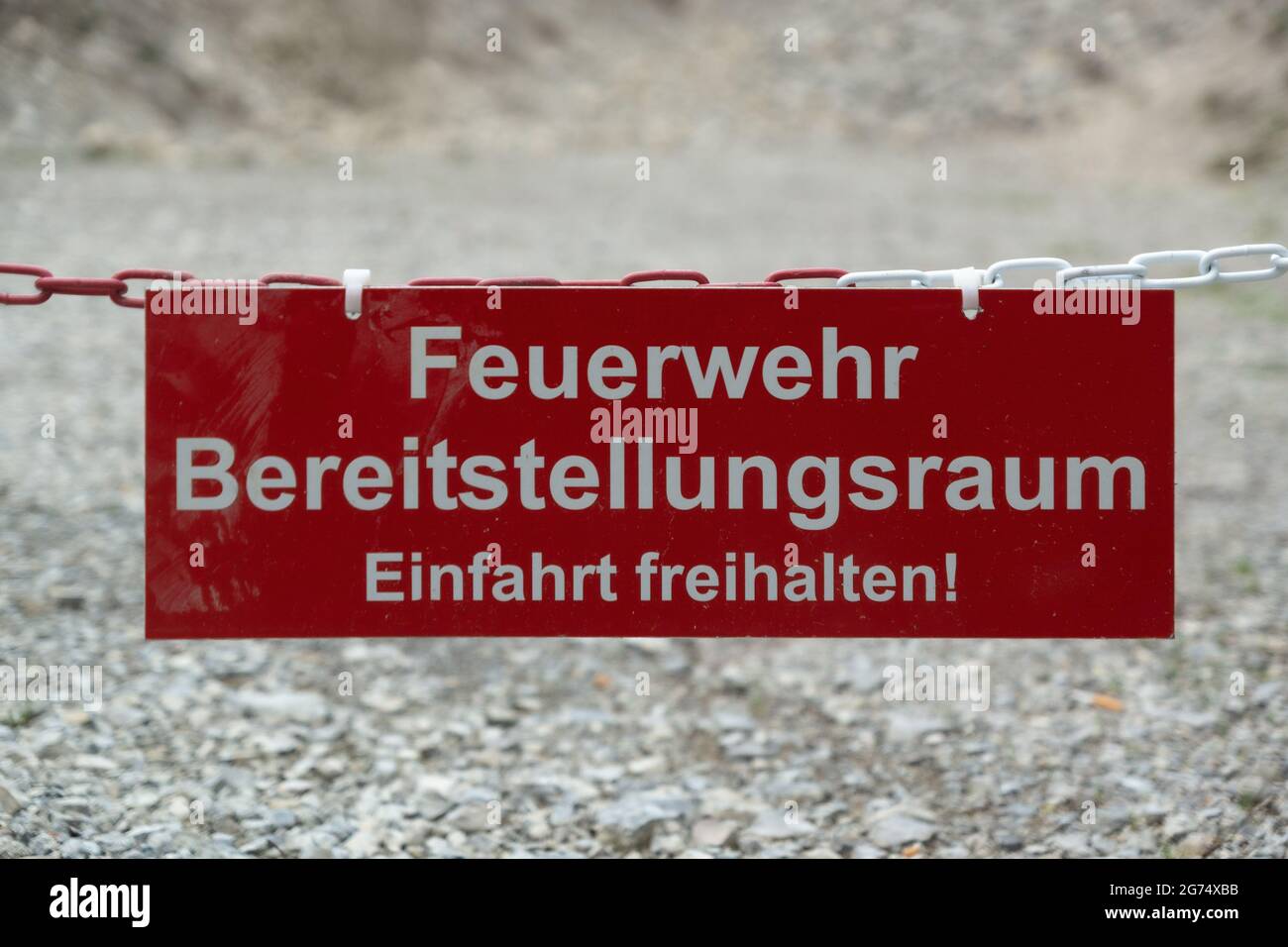Un segnale di avvertimento basso con il testo 'Feuerwehr bereitstellungsraum, einfahrt freihalten' Foto Stock
