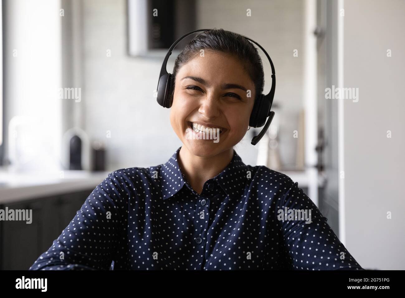 Felice divertente studente indiano che indossa cuffie e microfono Foto Stock