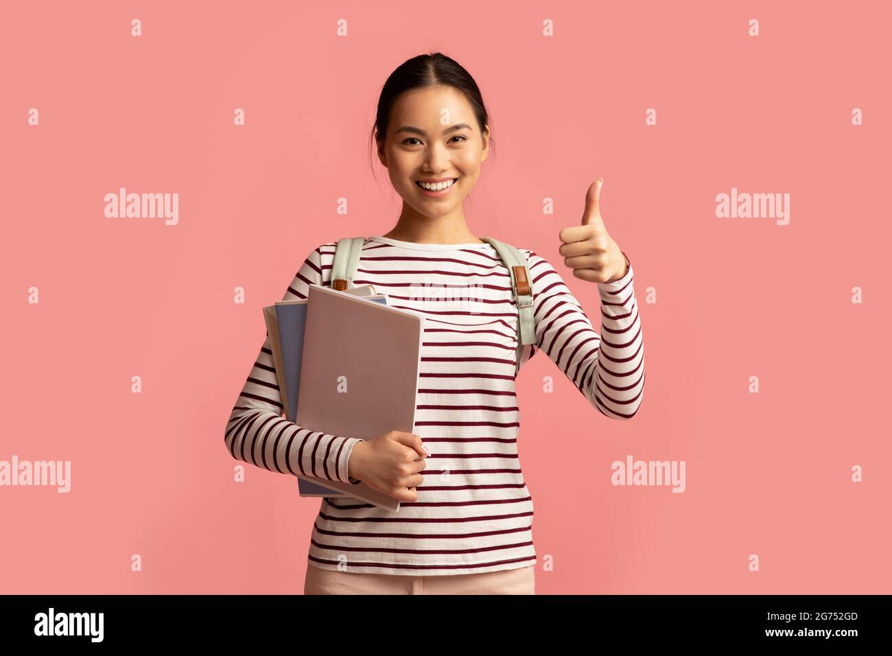 Ritratto di allegro Asian studentessa Borse di lavoro e mostrando Thumb Up Foto Stock