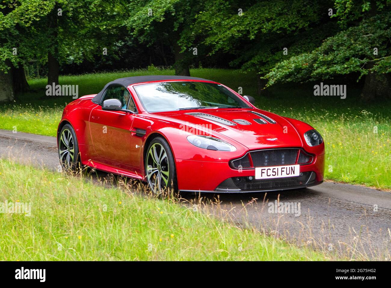 Una vista frontale di 2015 rosso Aston Martin 5933cc benzina coupé; auto classica retro libertà conducente auto Foto Stock