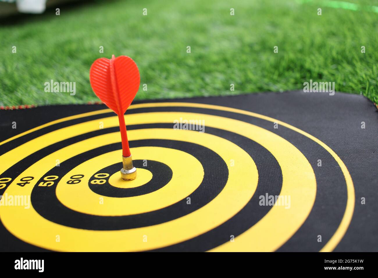 Freccia rossa che colpisce nel centro di destinazione della tavola da disegno con un bel terreno posteriore. Concetto di successo aziendale mostrato con Dart e dartboard. Obiettivo di marketing Foto Stock