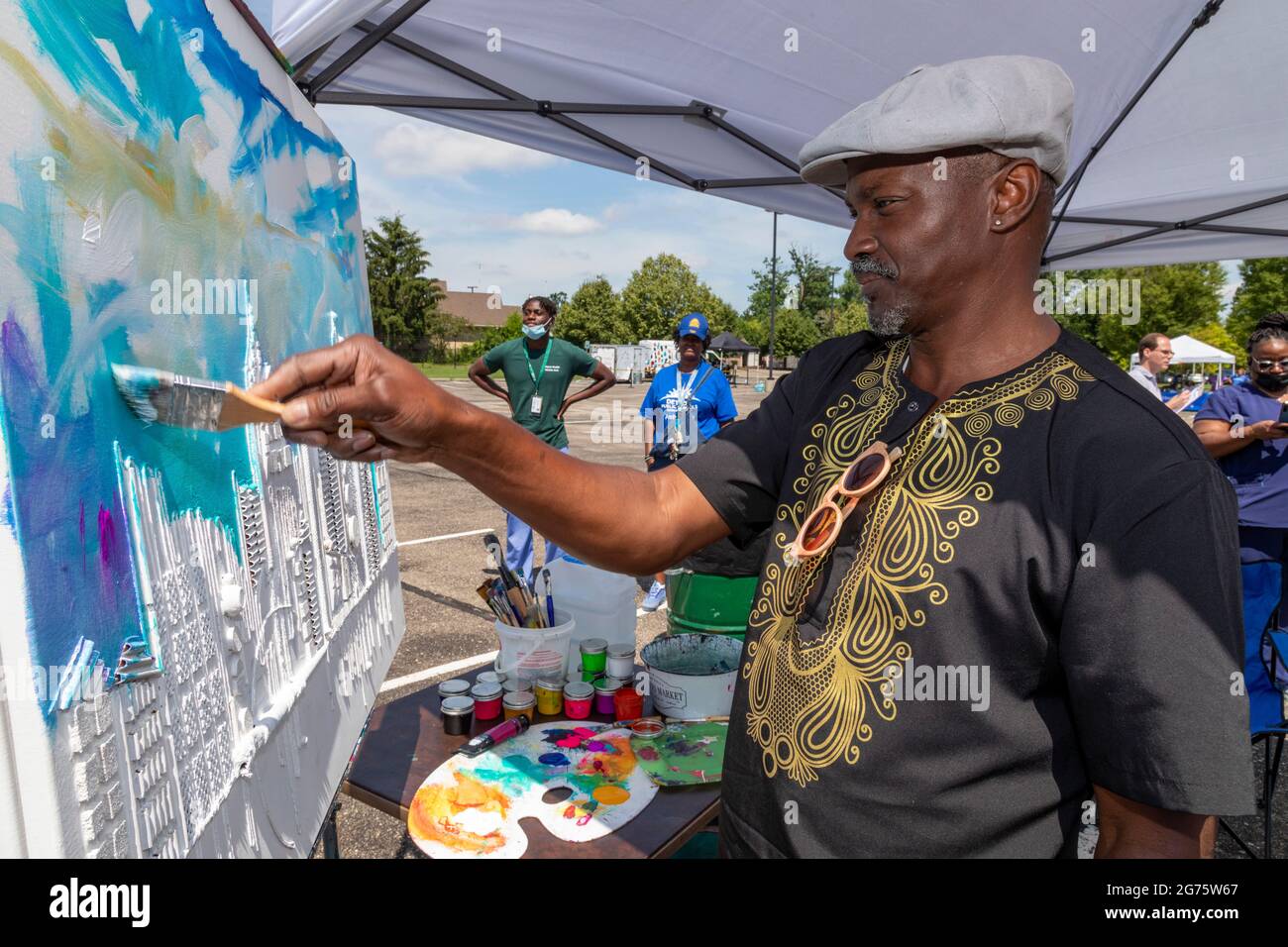 Detroit, Michigan - l'artista Timothy Orikri dimostra la sua pittura in un festival comunitario di arte e musica. Figlio di un ministro Battista, Orikri immi Foto Stock